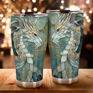 May include: Two stainless steel tumblers featuring a colourful stained glass design of a dragon. The tumblers have the name "Jennifer" printed on them.