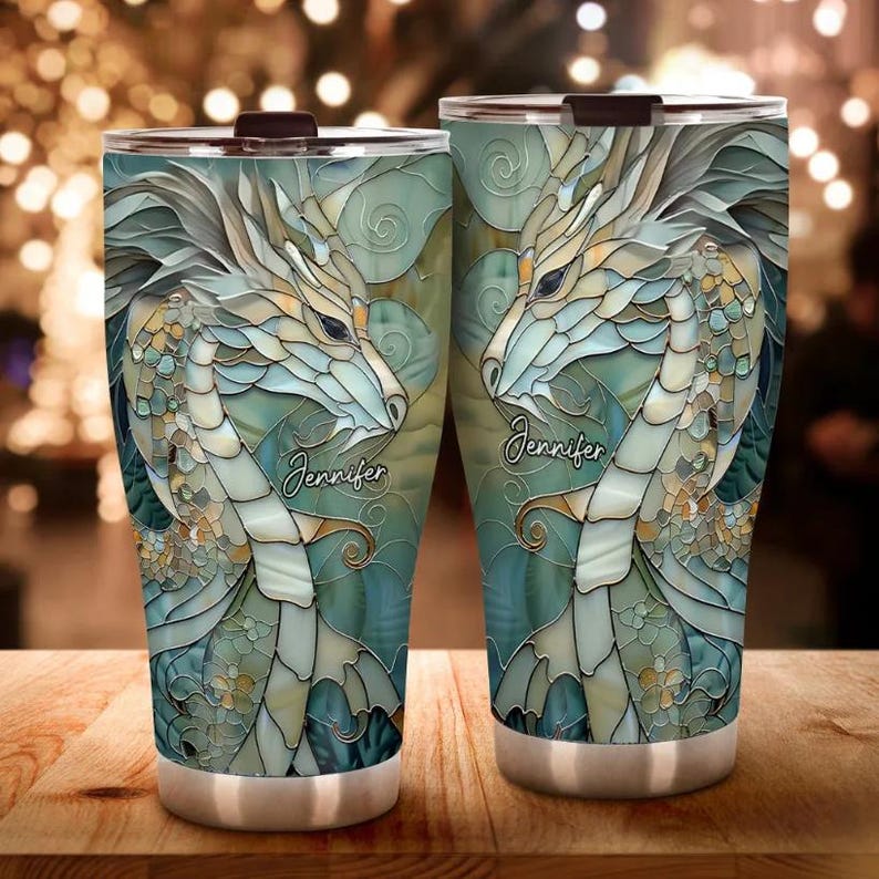 May include: Two stainless steel tumblers featuring a colourful stained glass design of a dragon. The tumblers have the name "Jennifer" printed on them.
