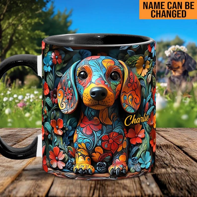 Puede incluir: Una taza de caf&eacute; negra con un dise&ntilde;o de dachshund colorido. El dachshund est&aacute; decorado con patrones florales en tonos de azul, rojo, amarillo y verde. La taza tiene el nombre "Charlie" escrito en ella.