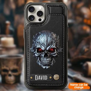 May include: Black leather phone case with a detailed silver skull design and red eyes. The case has a card slot and the name "DAVID" is printed on the bottom. The text "Name can be change" is also visible.