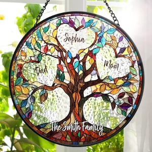 May include: A stained glass window hanging with a colourful tree design. The tree has three heart-shaped leaves with the names "Sophia", "Dad", and "Mom" inscribed. The text "The Smith Family" is at the base of the tree.