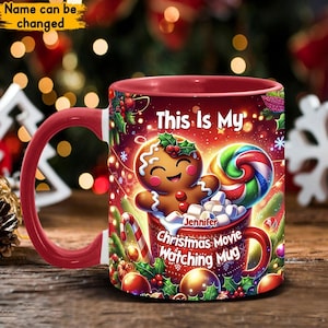 Könnte beinhalten: Rote und weiße Weihnachts-Tasse mit einem Lebkuchenmann, Zuckerstange und Marshmallows. Auf der Tasse steht "This is my Jennifer Christmas Movie Watching Mug".