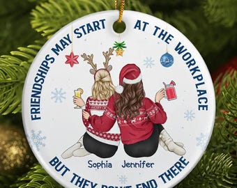 May include: White round ornament with a blue border and the text "Friendships may start at the workplace but they don't end there". The ornament features a cartoon illustration of two women wearing red and white sweaters with the names "Sophia" and "Jennifer" written below.