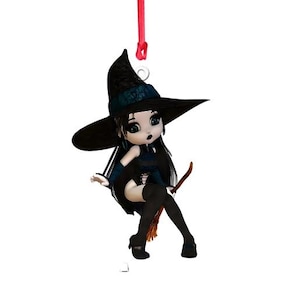 May include: A black witch doll with long black hair, wearing a black and blue dress, riding a broomstick. She is wearing a black witch hat with a red ribbon.