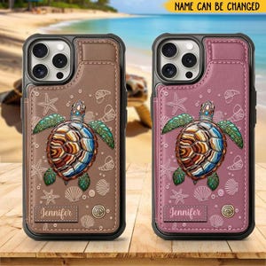 以下が含まれることがあります： 海亀のデザインの携帯電話ケースが2つ。1つは茶色、もう1つはピンクです。どちらのケースにも、カラフルなカメ、ヒトデ、貝殻の模様があります。「Jennifer」という名前が各ケースの小さなラベルに印刷されています。