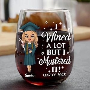 May include: A stemless wine glass with a graduation cap design and the text "I Wined A Lot But I Mastered It! Class of 2025". The glass has a cartoon image of a female graduate holding a diploma and a book. The name "Jessica" is printed on the bottom of the glass.