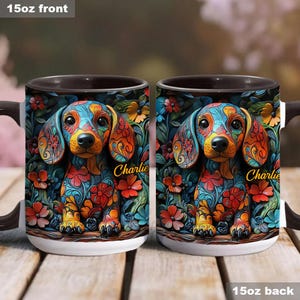 Puede incluir: Dos tazas de cer&aacute;mica blanca de 15 onzas con interiores negros. Ambas tazas presentan una ilustraci&oacute;n colorida de un dachshund con el nombre "Charlie" impreso en el lateral. El dachshund est&aacute; rodeado de flores y hojas.