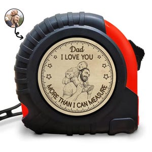 May include: A black and red tape measure with a wooden face. The wooden face has the text "Dad I LOVE YOU MORE THAN I CAN MEASURE" and an image of a father and child. A small photo is in the upper left corner.