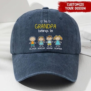 May include: A dark blue baseball cap featuring a graphic print with the text This GRANDPA belongs to, accompanied by four cartoon figures labeled Oliver, Amelia, Noah, and Sophia, each wearing colorful clothing and standing in a row.