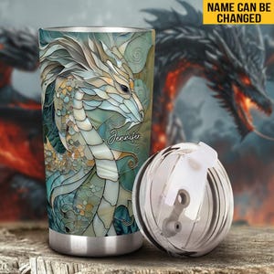 May include: Stainless steel tumbler featuring a colourful stained glass dragon design. The tumbler has a lid with a straw hole and the name "Jennifer" is printed on the side.