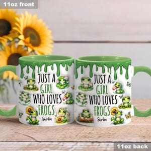 May include: A white ceramic mug with a green rim and a green dripping design. The mug features a cartoon frog design and the text "Just a girl who loves frogs". The mug is personalized with the name "Sophia".