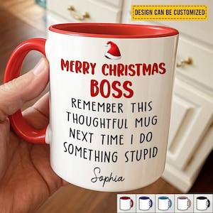 May include: A white ceramic mug with a red interior and handle. The mug features the text "MERRY CHRISTMAS BOSS" and a Santa hat graphic. Additional text reads "REMEMBER THIS THOUGHTFUL MUG NEXT TIME I DO SOMETHING STUPID" and the name "Sophia".