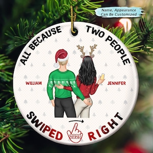 May include: A white round Christmas bauble featuring a couple in winter clothing. The bauble has the text "All because two people swiped right 2023". The couple are wearing red and green jumpers and the woman is holding a glass of champagne. The bauble is personalised with the names "William" and "Jennifer".
