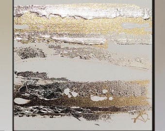 May include: Abstract art piece with a textured surface. The artwork features horizontal brushstrokes in silver, gold, and brown against a white background. The painting is framed in a black border, creating a modern aesthetic.