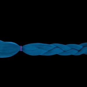 May include: A single, long, braided hair extension in a vibrant teal colour. The braid is secured with a small purple elastic band and a gold-coloured clasp at the end. The background is solid black.