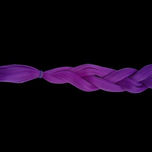 May include: A neatly braided section of purple hair extensions, fastened with a blue elastic band. The hair is a vibrant shade of purple, with a smooth, glossy texture. The braid is well-formed, highlighting the hair's colour and style against a black backdrop.
