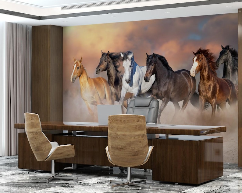 May include: A wall mural featuring a group of seven horses running through a field. The horses are all different colors, including brown, white, and black. The background is a sunset sky with clouds.