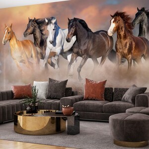 May include: A group of seven horses running through a dusty field. The horses are all different colors, including brown, white, and black. The horses are running towards the camera, and the dust is kicking up behind them.