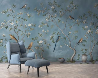 May include: A serene interior scene featuring a blue armchair and ottoman set against a backdrop of a mural. The mural depicts a stylized tree with white flowers and birds. The room has a light blue color scheme and a wooden floor.