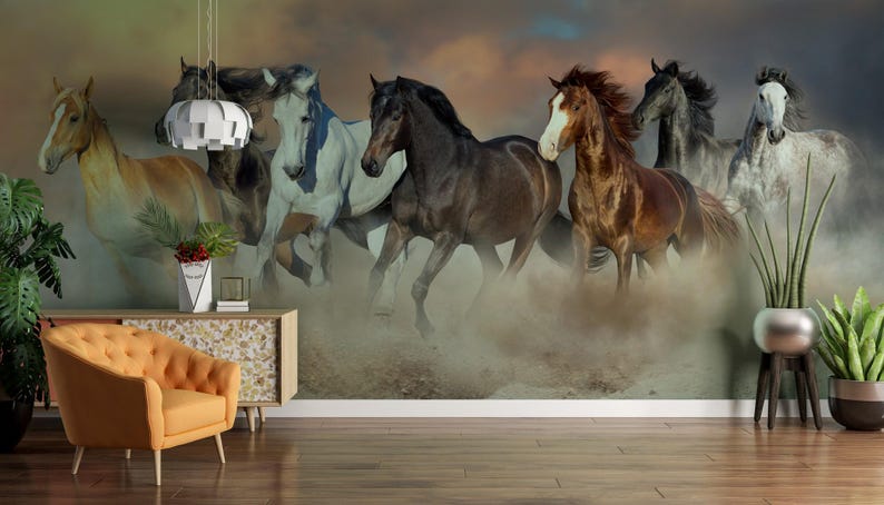 May include: A group of seven horses running through a dusty field. The horses are all different colors and breeds, and they are running in a loose formation. The background is a blurry image of a sunset.