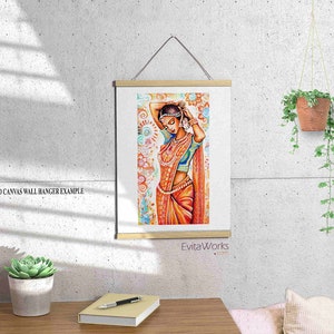 May include: A framed print of an Indian woman in traditional attire, with orange and blue tones. The artwork is displayed on a wall with a wooden frame and a hanging cord. The text "EvitaWorks.com" is visible.
