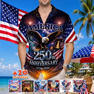 Puede incluir: Una camisa de manga corta con un diseño patriótico. La camisa presenta un águila, la Estatua de la Libertad y el texto "AMERICA 250th ANNIVERSARY 1776-2026". La camisa tiene un fondo azul oscuro con fuegos artificiales y elementos de la bandera estadounidense.