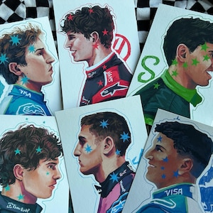 Op de afbeelding: Vijf verschillende stickers met portretten van racecoureurs. Elke sticker heeft een blauwe, groene of rode achtergrond met een witte omtrek. De coureurs dragen racepakken en helmen. De stickers hebben een sterrenpatroon.