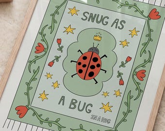 Puede incluir: Una impresión rectangular enmarcada con fondo verde claro, una mariquita roja y negra con una pequeña corona amarilla en el centro. El texto dice SNUG AS A BUG. El borde incluye flores rojas, enredaderas verdes y estrellas amarillas.