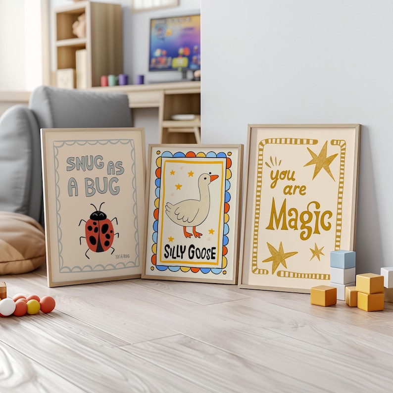 May include: Three framed art prints with whimsical designs. One says "Snug as a Bug" with a ladybug illustration. Another says "Silly Goose" with a goose illustration. The third says "You are Magic" with star accents.