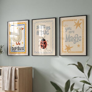 May include: Three framed art prints with whimsical designs. One features a goose with the text "Silly Goose", another a ladybug with "Snug as a Bug", and the last with stars and "You are Magic".