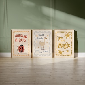 May include: Three framed art prints with whimsical designs. One features a ladybug with the text "Snug as a Bug." Another shows a goose with the text "Silly Goose on the Loose." The third print has the text "You are Magic" with star accents. All prints have a cream background.
