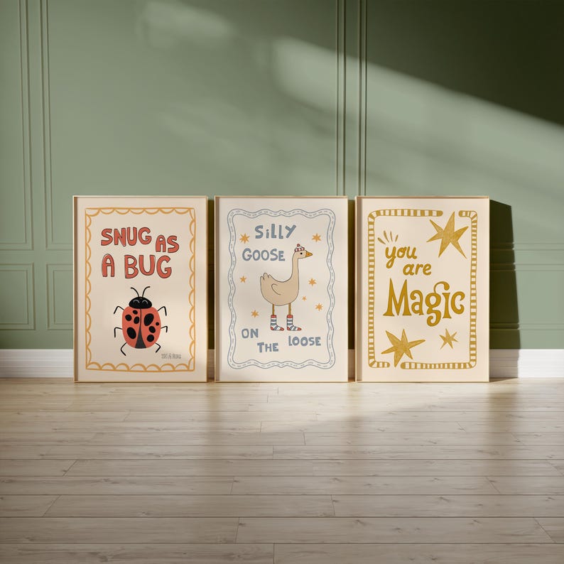 May include: Three framed art prints with whimsical designs. One features a ladybug with the text "Snug as a Bug." Another shows a goose with the text "Silly Goose on the Loose." The third print has the text "You are Magic" with star accents. All prints have a cream background.