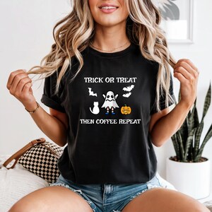 Peut inclure: T-shirt noir avec l'inscription "Trick or Treat Then Coffee Repeat" et des graphiques d'Halloween. Le motif comprend un fantôme, un chat, des chauves-souris et une citrouille. Le t-shirt est de style décontracté.