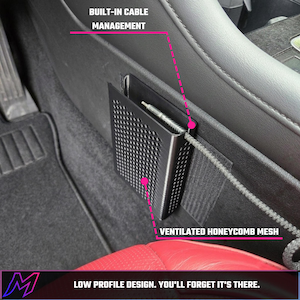May include: A black car storage pocket with a ventilated honeycomb mesh design and built-in cable management. The rectangular organizer is mounted to the side of a vehicle interior console, featuring a low profile design and a cable.
