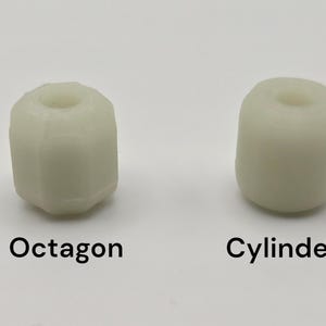 May include: Two off-white, cylindrical objects. One is an octagon shape, the other is a cylinder. The word "Octagon" is printed below the octagon shape. The word "Cylinder" is printed below the cylinder shape. Both objects have a hole in the center.
