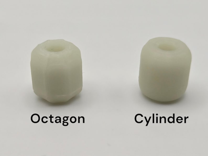 May include: Two off-white, cylindrical objects. One is an octagon shape, the other is a cylinder. The word "Octagon" is printed below the octagon shape. The word "Cylinder" is printed below the cylinder shape. Both objects have a hole in the center.