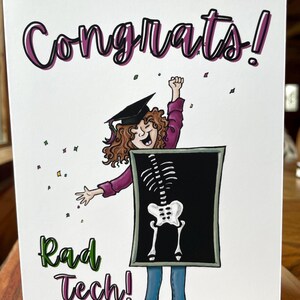 May include: A graduation card with the words "Congrats!" in purple and black. The card features a cartoon illustration of a graduate wearing a cap and holding a skeleton x-ray. The words "Rad Tech!" are written in green and purple.