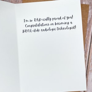 May include: A white greeting card with the text "I'm so RAD-ically proud of you! Congratulations on becoming a BONE-ifide radiologic technologist!" The card is inside a brown envelope.