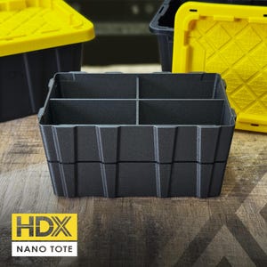May include: A black plastic storage bin insert with four internal compartments, designed to fit inside a larger container. The insert features a textured finish and vertical structural ribs along the exterior walls. The HDX NANO TOTE logo is visible.