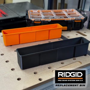 Op de afbeelding: Een zwart-oranje Ridgid Pro Gear System Gen 2.0 opbergkoffer met een doorzichtig deksel, vergezeld van een losse oranje rechthoekige opbergbak en een zwarte rechthoekige opbergbak, beide voorzien van interne verdelers voor organisatie.