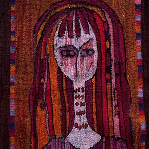Puede incluir: Tapiz tejido que presenta un retrato estilizado. La obra de arte presenta una persona con pelo largo rojo y un vestido morado, sobre un fondo marrón. La paleta de colores incluye rojo, naranja y morado. La cara es blanca con ojos oscuros.