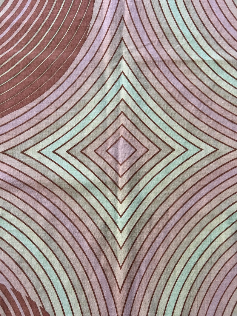 May include: A fabric with a geometric pattern of overlapping circles and diamonds in shades of brown, purple, and green.