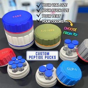 May include: A collection of custom peptide pucks in various colors including blue, red, olive green, and gray. These cylindrical organizers feature textured sides and lids labeled with text like TIRZ, CJC-1295, TB-500, BPC-157, and GLP-1. Small glass vials with blue caps are held within the pucks.