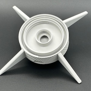 May include: A light gray circular component featuring a central threaded opening and four radiating pointed arms. The outer edge of the cylindrical base displays a textured, diamond-patterned grip, providing a functional design for this mechanical part.