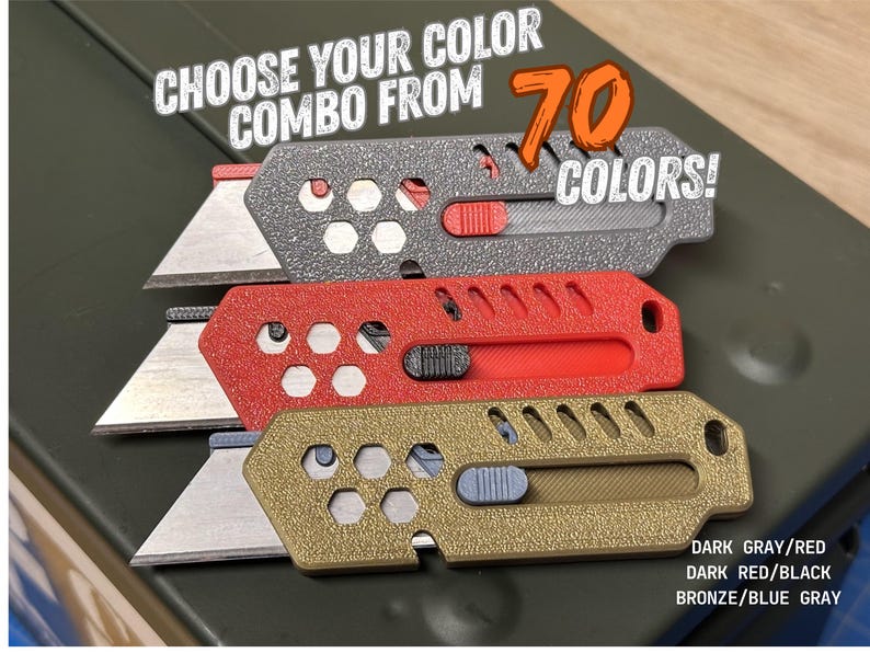 close-up of three, colored, stylized pocketknives. the blades are extended on all three. one is silver with a red button, the second is red with a black button, and the third is bronze with a gray button. all three sit atop the lid of a dark green metal ammo can. there is white and orange text across the top encouraging people to choose from 70 color options.