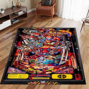 Puede incluir: Una máquina de pinball negra y roja con temática de Deadpool. La máquina tiene una tapa de vidrio y un marco de metal. La mesa de pinball presenta un diseño colorido con una variedad de personajes y objetos. La máquina tiene una señal de advertencia negra y amarilla con el texto "¡Peligro!"
