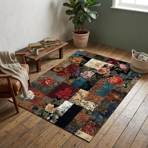 May include: A rectangular area rug with a patchwork design featuring floral patterns in shades of red, orange, yellow, blue, and cream. The rug is placed on a wooden floor, with a chair and small table visible in the background.