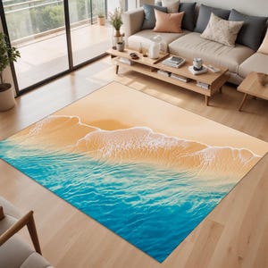 May include: A rectangular area rug featuring a beach scene with a sandy shore and ocean waves. The rug's design includes a gradient of colors, transitioning from a light tan beach to turquoise blue water. The waves have white foamy crests.