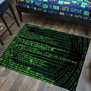 Op de afbeelding: Een zwart en groen vloerkleed met een patroon van groene code op een zwarte achtergrond. De code is in een cirkelvormig patroon.