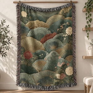 May include: A woven throw blanket featuring a repeating fan-shaped pattern in shades of deep green, gold, and muted red. The design includes detailed floral motifs of chrysanthemums throughout the fabric, finished with a fringed edge.